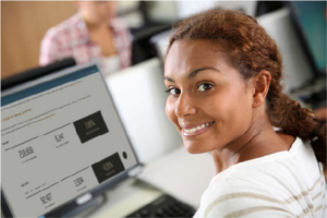 Photo of a smiling female using a computer.