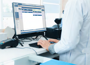 Photo of a laboratory technician working on the computer with the Orchard Software application on the screen.