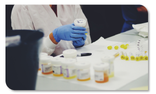 Photo of lab technician add a label to a sample container.