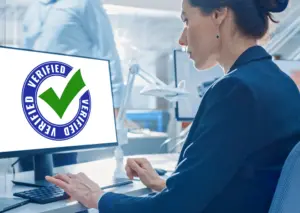 Image of a female looking at a computer monitor with a check mark and the word "Verified."