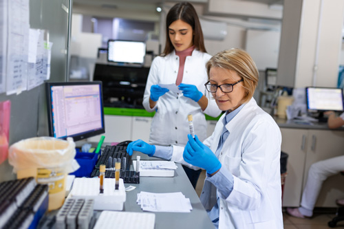 two women working at a computer accessioning laboratory samples